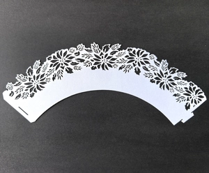 Detailed laser-cut white lace cupcake wrapper with intricate floral hollow-out design