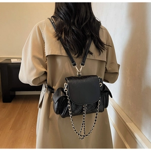 Vue détaillée d'un sac à dos noir matelassé avec chaînes dorées et poches latérales chic