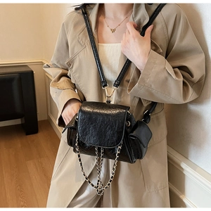 Vue détaillée de la texture en cuir noir matelassé et de la chaîne dorée du sac à main