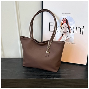 Close-up of deep brown lychee texture leather tote bag with elegant gold chain detail