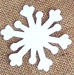 Close-up of white snowflake laser-cut paper cards on a rustic brown burlap background