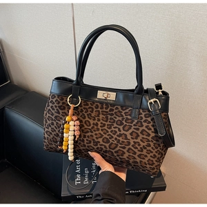 Dettaglio della borsa leopardata con chiusura a rotazione in metallo e charm di perline