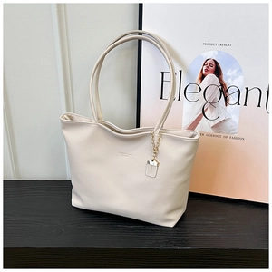Close-up of cream white textured leather tote bag with elegant chain pendant detail