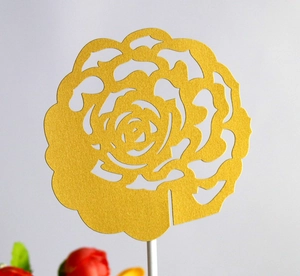 Golden laser-cut flower cake topper with intricate rose petals and white support rod