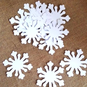 Detail of laser-cut white snowflake cards on vintage brown burlap for Christmas decor