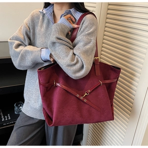 Detail of burgundy matte tote bag featuring decorative straps and textured frosted finish