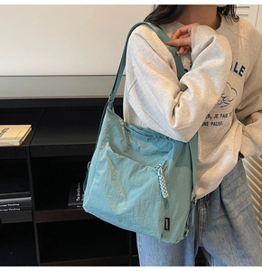 Detailed shot of Morandi cyan nylon hobo bag featuring logo tag and textured fabric