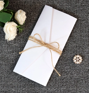 Elegant white wedding invitation envelope with natural twine bow and pearl floral ornament