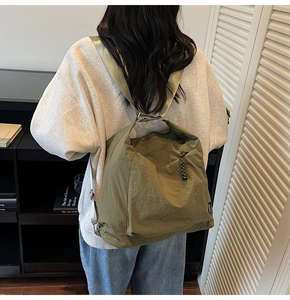 Detail view of olive green oversized tote bag with pleated texture and wide shoulder strap