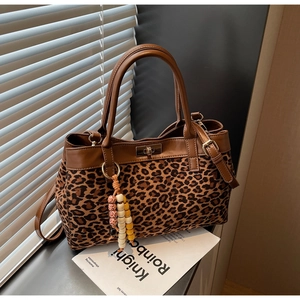 Dettaglio della borsa tote leopardata in pelle scamosciata con chiusura a rotazione