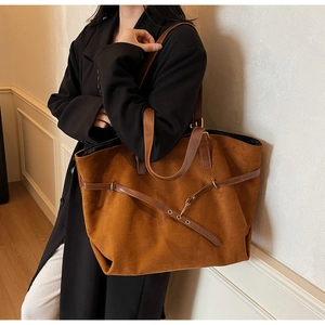 Detail showing vintage caramel suede tote bag with double leather handles and metal ring