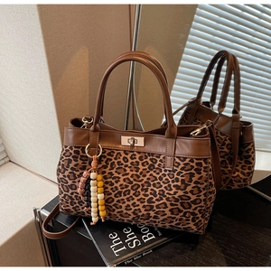 Dettaglio borsa in pelle scamosciata leopardata con chiusura in metallo e nappe con perline