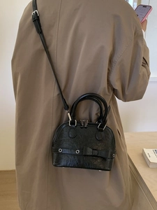 Chic black shell-shaped leather handbag with bow detail and silver hardware