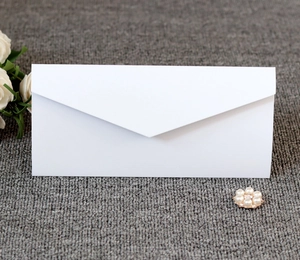 Elegant white V-flap envelope on grey texture with decorative pearl and floral accents