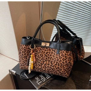 Dettaglio della borsa leopardata con chiusura a rotazione in metallo e charm di perline