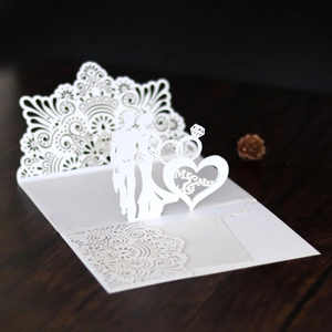 Macro detail of laser-cut 3D wedding invitation with Mr & Mrs silhouette on wood