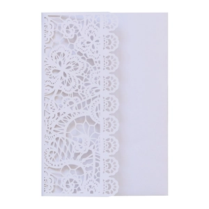 Close-up of laser-cut lace floral pattern on elegant white paper wedding invitations