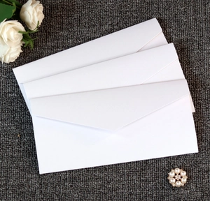 Three minimalist cream white wedding invitation envelopes with elegant matte paper texture