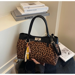 Dettaglio borsa tote leopardata in pelle scamosciata con finiture in pelle e ciondolo
