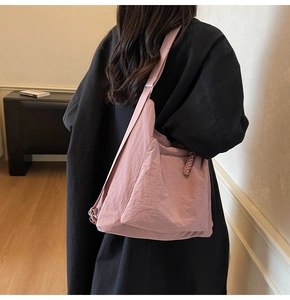 Detailed side view of a large pink nylon tote bag showing soft texture and wide strap