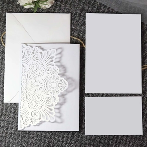 Detailed laser-cut wedding invitation set with floral hollow pattern and white envelopes