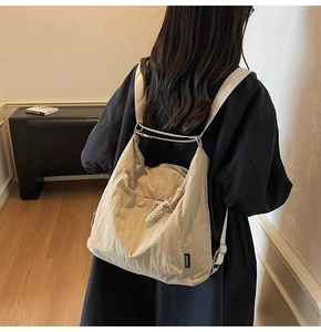 Detailed back view of a beige minimalist large capacity backpack with adjustable straps
