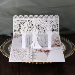 Macro shot of 3D laser cut wedding invitation card with intricate lace floral arch design