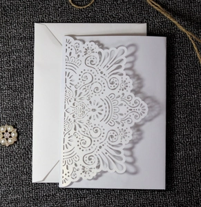Detailed laser-cut floral wedding invitation card with matching white envelope
