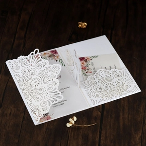 Detail der lasergeschnittenen Hochzeitseinladung mit weißem Muster und Blumen-Innenkarte