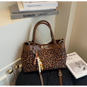 Dettaglio della borsa tote in pelle scamosciata leopardata con finiture in pelle marrone