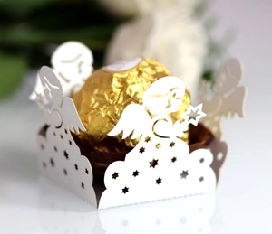 Macro detail of white laser-cut angel paper candy box for wedding dessert decoration