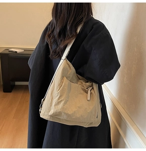 Macro view of light khaki nylon shoulder bag with woven rope detail and wide strap