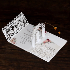 Detail view of a 3D laser-cut wedding invitation featuring intricate white lace patterns