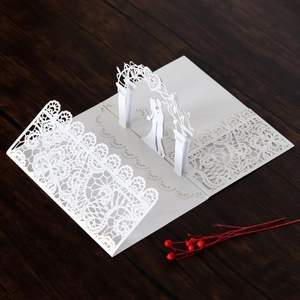 Detailed laser-cut lace wedding pop-up card featuring a bride and groom under a floral arch