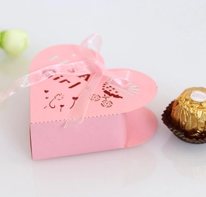 Pink heart-shaped candy gift box for baby shower featuring It's a girl cutout and pink ribbon