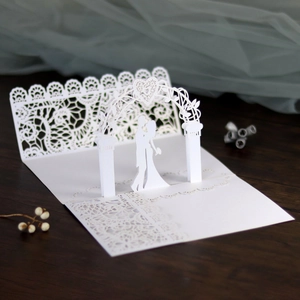 Macro detail of laser-cut 3D wedding card with bride and groom silhouette and heart design