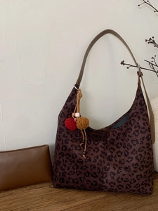 Sac hobo imprimé léopard marron et pochette sur surface en bois au style rétro