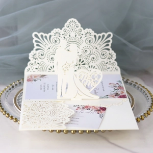 Makroaufnahme einer goldenen Laser-Hochzeitseinladung mit Mr & Mrs Silhouette und Blumendruck
