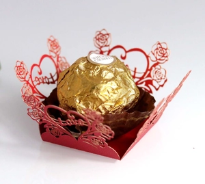 Macro view of laser-cut red rose and heart wedding favors wrap for chocolates