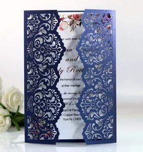 Close-up of laser-cut navy blue wedding invitation with elegant floral white insert