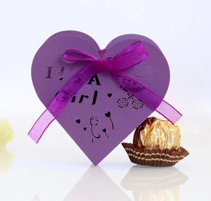 Macro shot of purple heart laser-cut favor box with IT'S A Girl text and organza ribbon