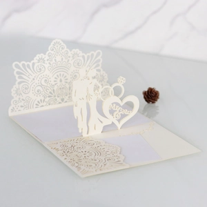 Macro view of 3D laser-cut wedding invitation featuring ivory paper and Mr & Mrs silhouette
