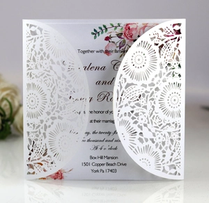 Detail of laser-cut lace wedding invitation with floral insert and elegant engraving