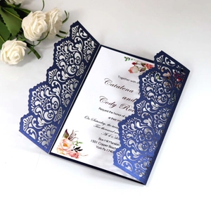 Detailed macro view of laser-cut navy blue wedding invitation with intricate vine patterns
