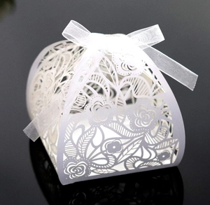 Macro-opname van witte lasergesneden geschenkdoos met bloemenpatroon en witte strik
