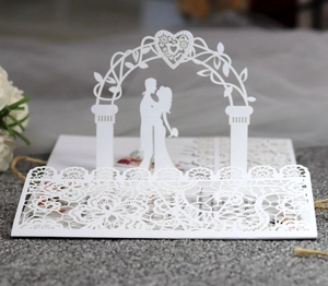 Detailed laser cut lace pattern and 3D heart arch on white wedding invitation card