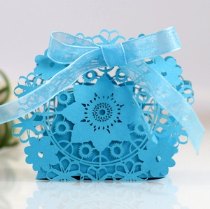 Detail of light blue laser-cut candy box featuring elegant floral patterns and a ribbon bow