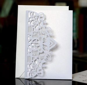 Motif floral découpé au laser sur d'élégantes cartes d'invitation de mariage blanc perlé