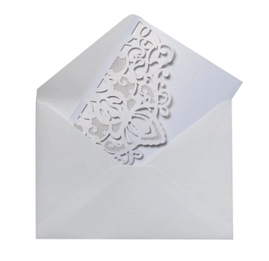Détail macro du motif floral découpé au laser sur carte d'invitation blanc nacré élégante