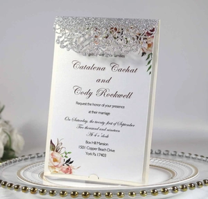 Macro detail of laser cut glitter silver invitation card with pink floral patterns